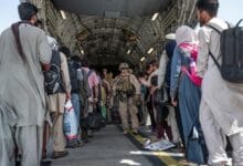 U.S. Airmen and U.S. Marines guide qualified evacuees aboard a U.S. Air Force C-17 Globemaster III at Hamid Karzai International Airport (HKIA), Afghanistan, August 21, 2021.