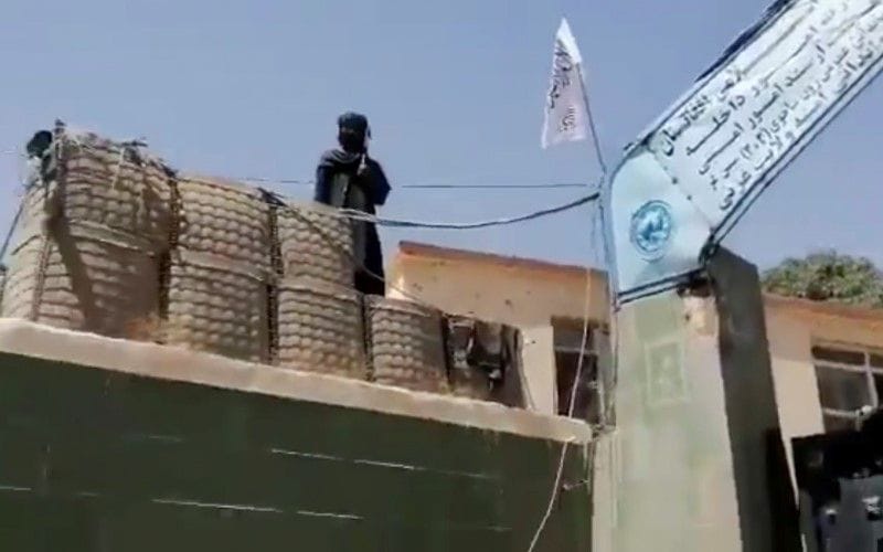 هرات تسقط بيد حركة طالبان، وعينهم على قندهار ... قريباً فيها ! 2 A fighter stands guard next to a Taliban flag raised at the gates outside the police headquarters, in city of Ghazni, Afghanistan in this screen grab taken from a video released by the Taliban on August 12, 2021. Taliban Handout/via REUTERS