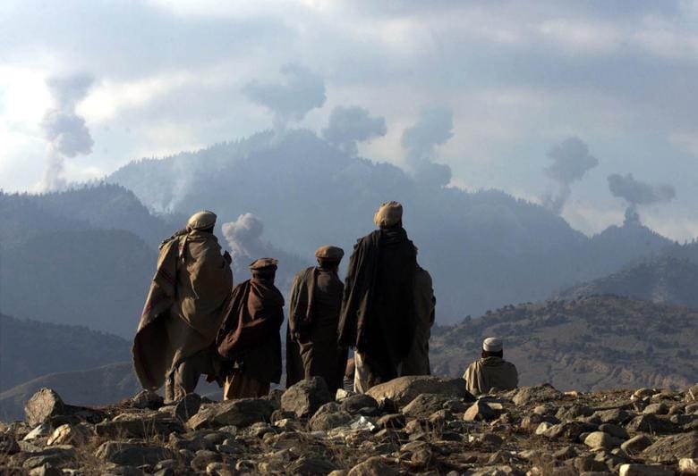 Anti-Taliban Afghan fighters watch several explosions from U.S. bombings in the Tora Bora mountains in Afghanistan, December 16, 2001. REUTERS/Erik de Castro
