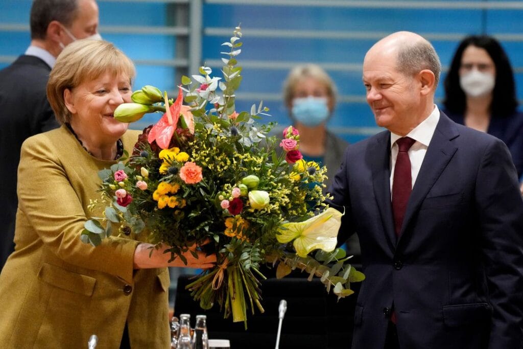 إئتلاف ( أحمر - أصفر - أخضر Traffic Light Coalition ) ـ أول إئتلاف فيدرالي ثلاثي في ألمانيا 2 Acting German Chancellor Angela Merkel receives a bouquet from acting German Finance Minister Olaf Scholz prior to the weekly cabinet meeting at the Chancellery in Berlin, Germany, November 24, 2021. Markus Schreiber/Pool via REUTERS