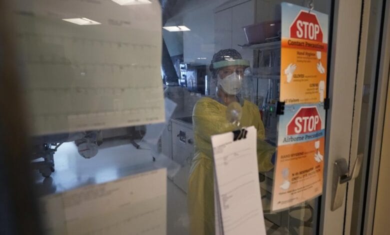 Registered nurse Morgan Flynn works inside a patient's room in the COVID-19 Intensive Care Unit at Dartmouth-Hitchcock Medical Center, in Lebanon, N.H., Monday, Jan. 3, 2022. Hospitalizations in U.S. children under age 5 with COVID have soared dramatically to unprecedented levels, a worrisone trend in youngsters too young to be vaccinated. (AP Photo/Steven Senne)
