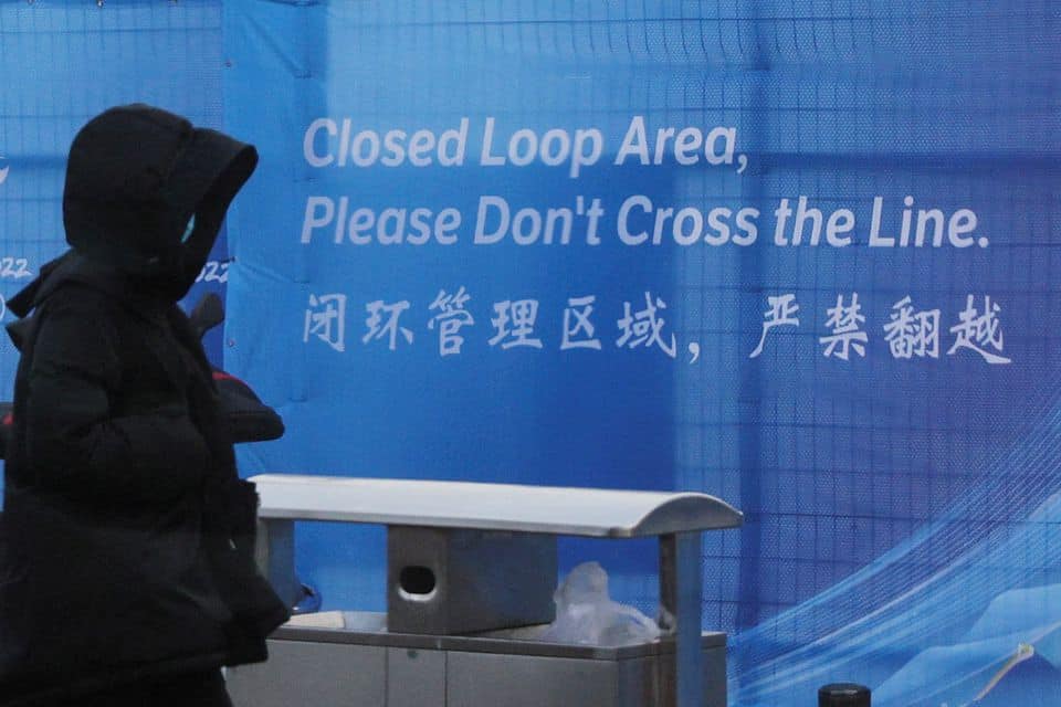A pedestrian passes a sign marking the barrier of the "Closed Loop," a precaution against the coronavirus disease (COVID-19) ahead of the Beijing 2022 Winter Olympics in Beijing, China, January 30, 2022. REUTERS/Brian Snyder