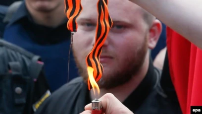Ukrainian nationalists burn a St. George ribbon during the Victory Day celebrations, marking the anniversary of the victory over Nazi Germany in World War II, in Kyiv on May 9.